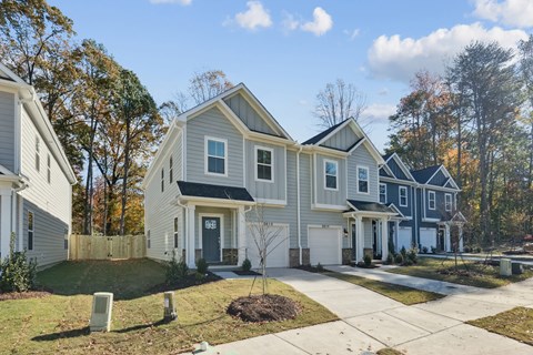 A row of houses with a white and blue one in the middle.
