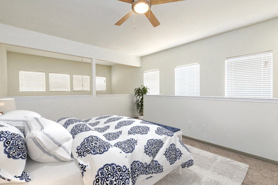 A bedroom with a bed and a ceiling fan.