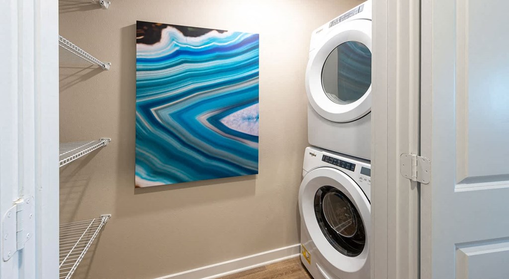 a laundry room with a washing machine and a painting on the wall