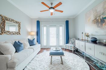 a living room with a white couch and a ceiling fan