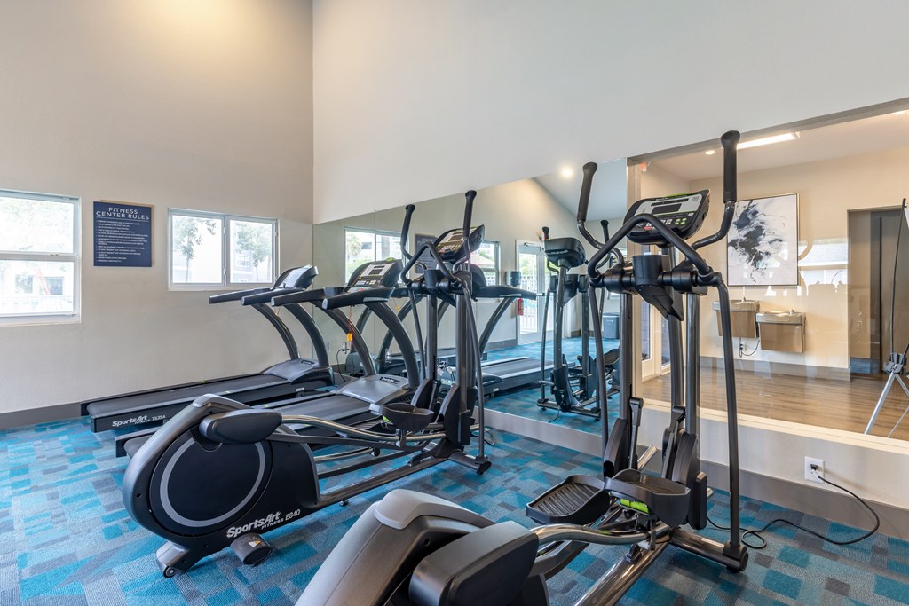 A gym with treadmills and elliptical machines.