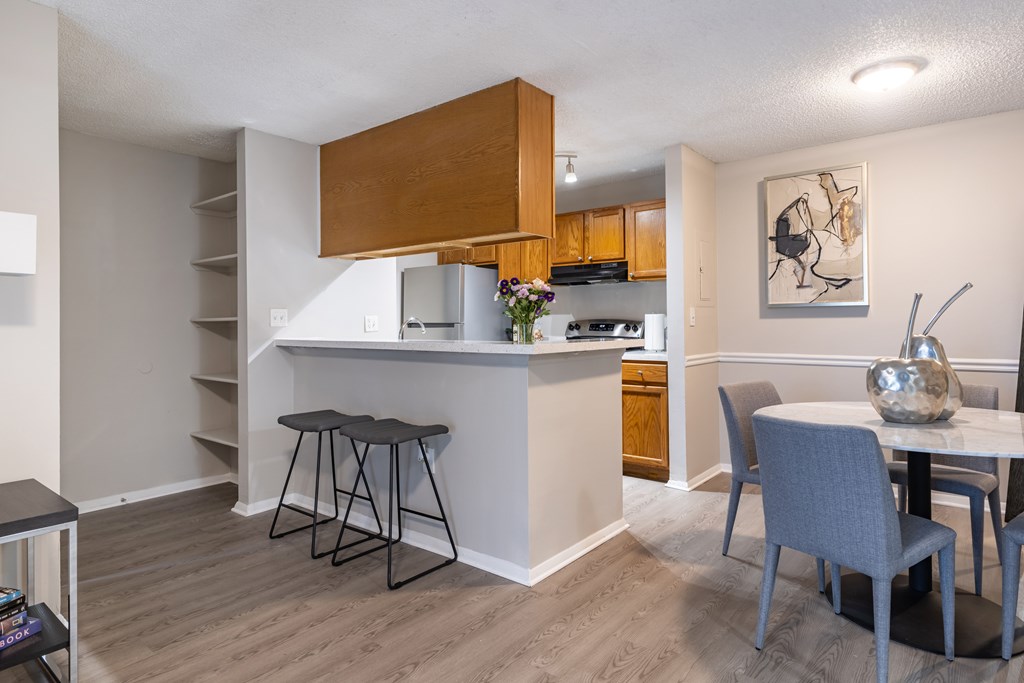 A kitchen with a table and chairs in front of it.