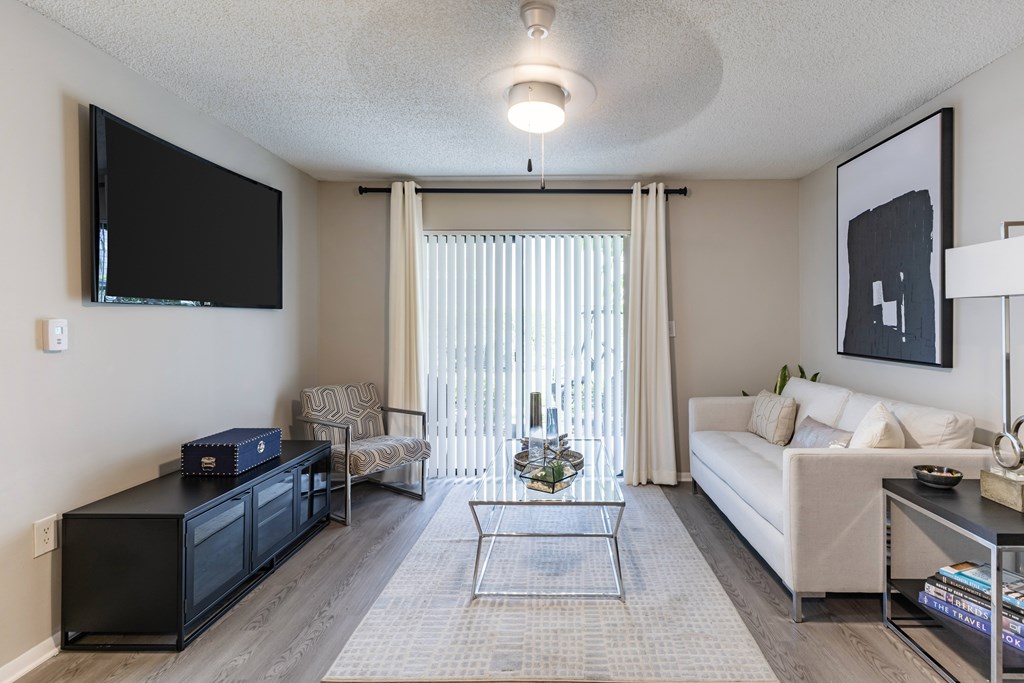 A living room with a black television and a white couch.