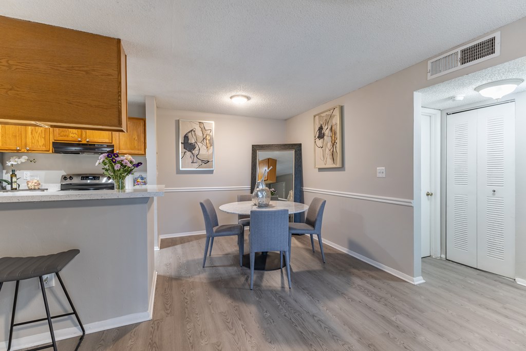 A dining room with a table and chairs.