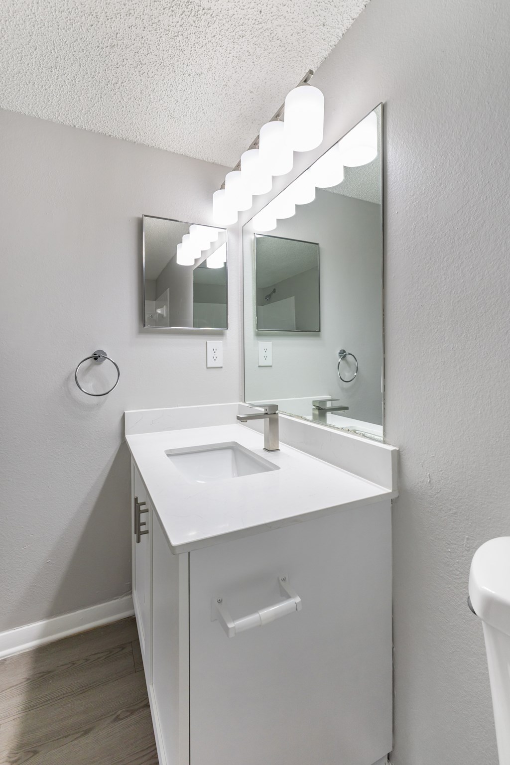 A white sink vanity with a mirror above it.