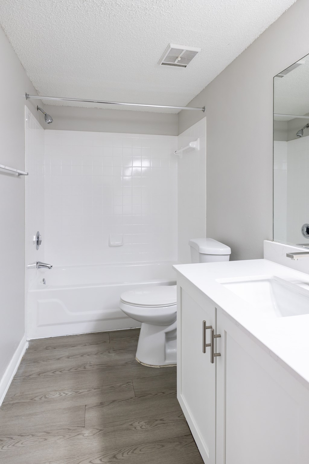 A white bathroom with a toilet, sink, and tub.