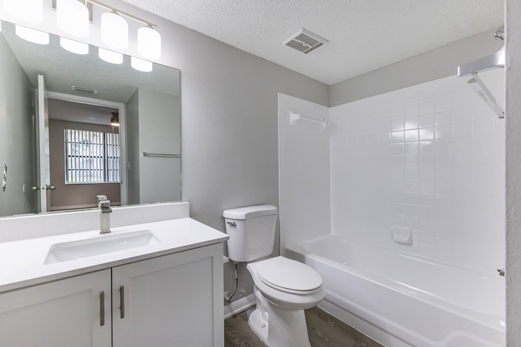 A white bathroom with a toilet, sink, and bathtub.