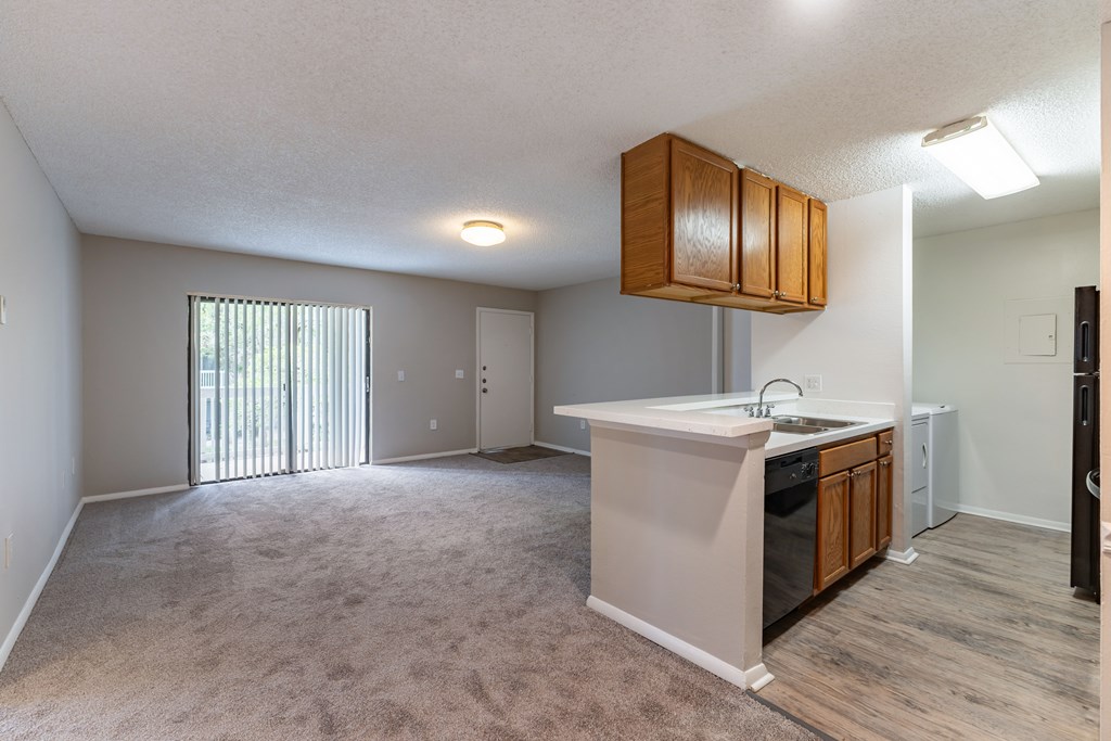 A kitchen area with a sink, stove, and cabinets.