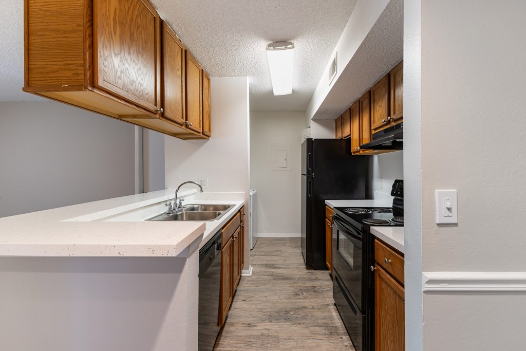 A kitchen with black appliances and wooden cabinets.