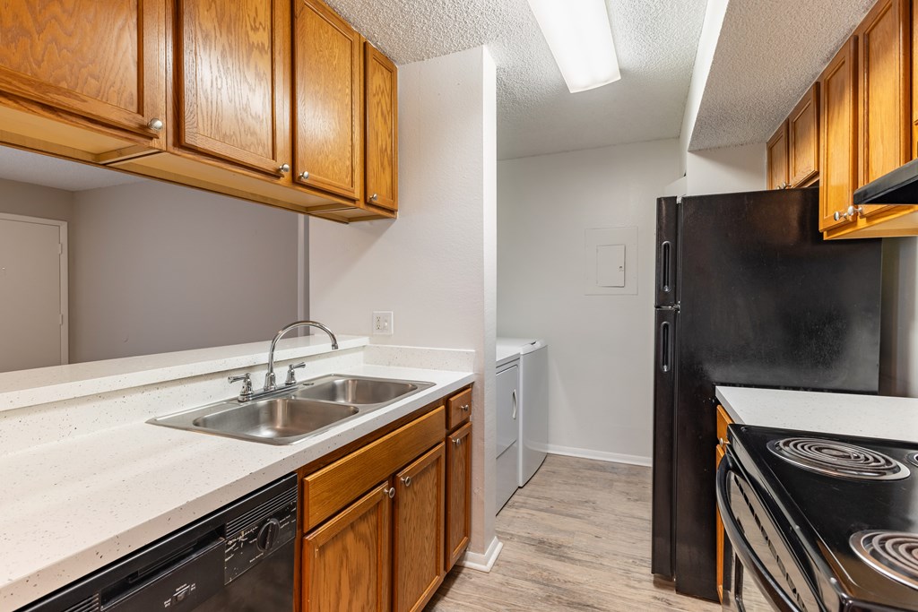 A kitchen with wooden cabinets and black appliances.