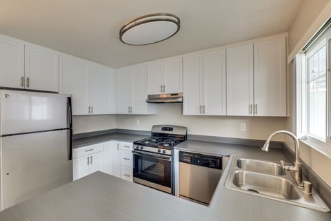A kitchen with white cabinets and stainless steel appliances.