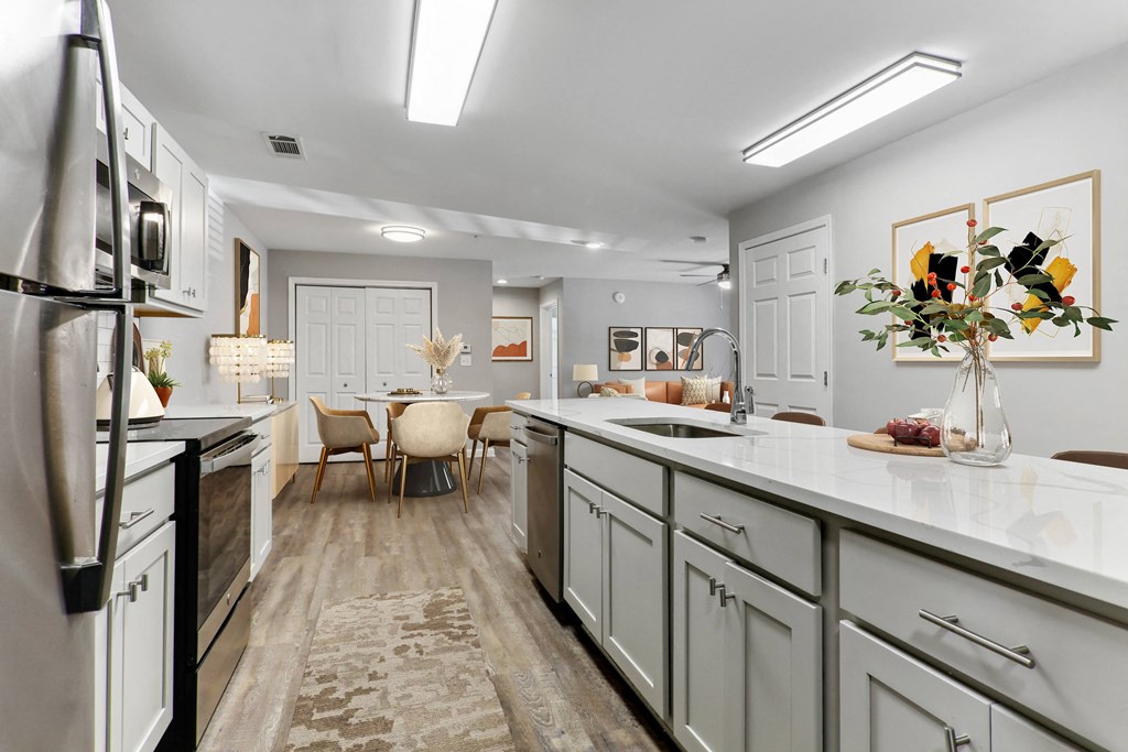a kitchen and dining room with white cabinets and white counter tops