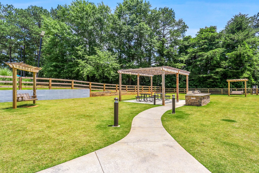 a path leading to a park with benches and structures