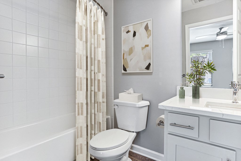 a white bathroom with a shower curtain and a toilet