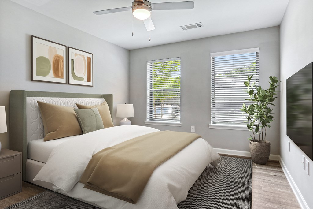 a bedroom with a large bed and two windows