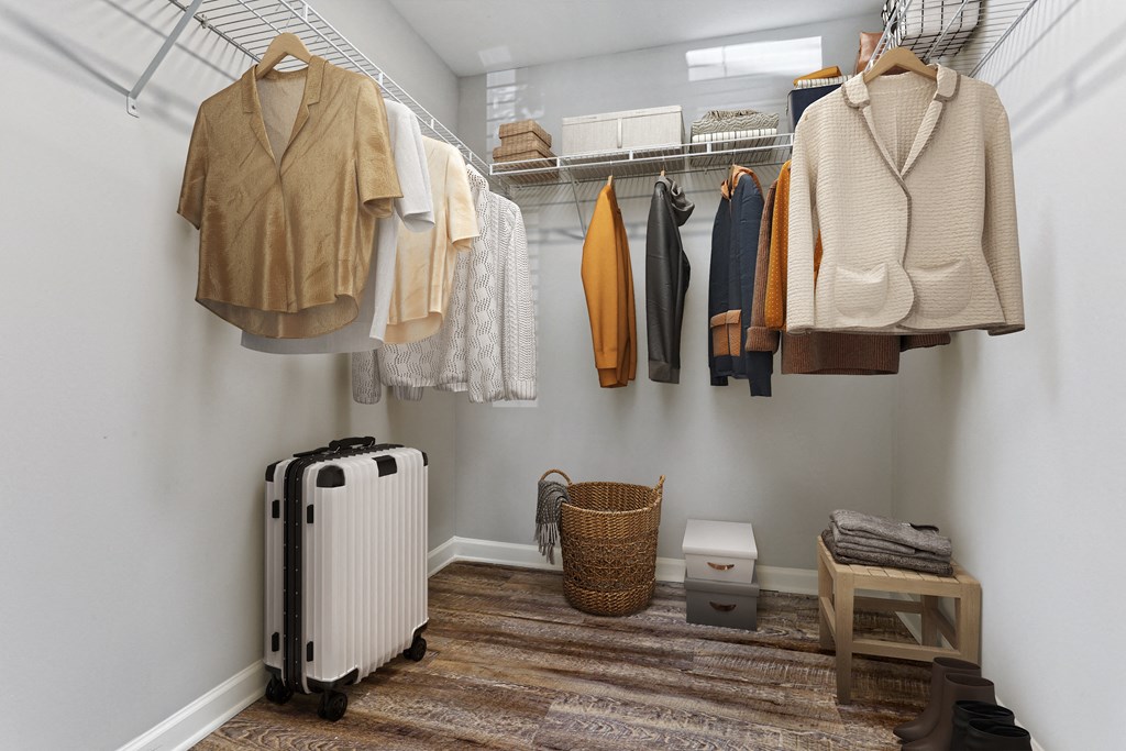 a closet with clothes hanging on a rack and a suitcase