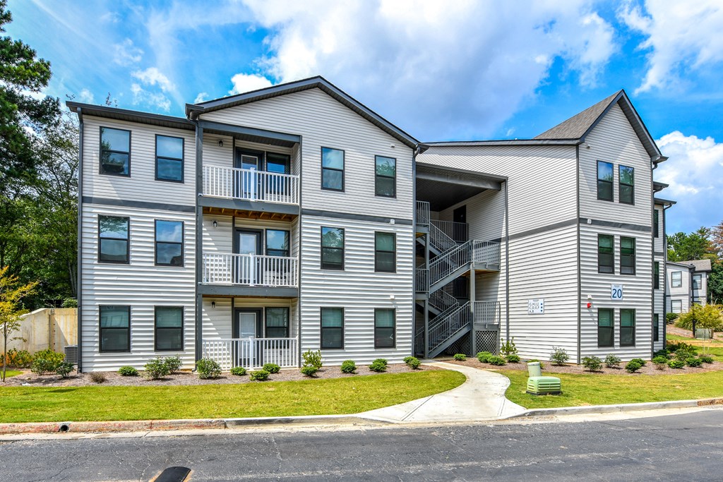 an apartment building with stairs on the side of a street