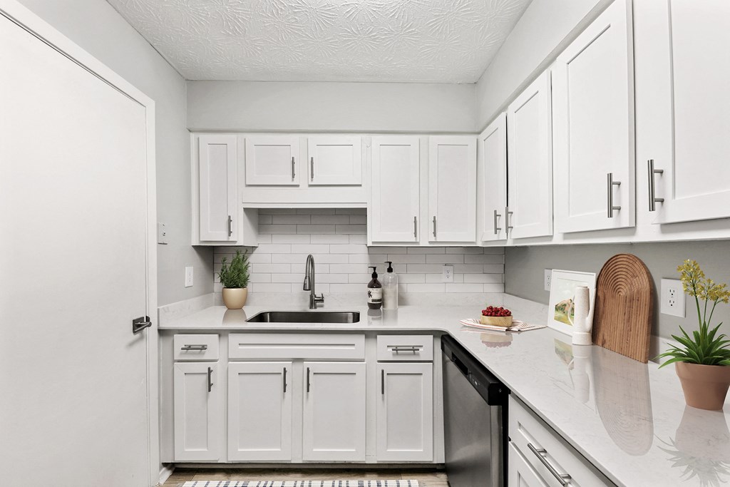 a white kitchen with white cabinets and a sink