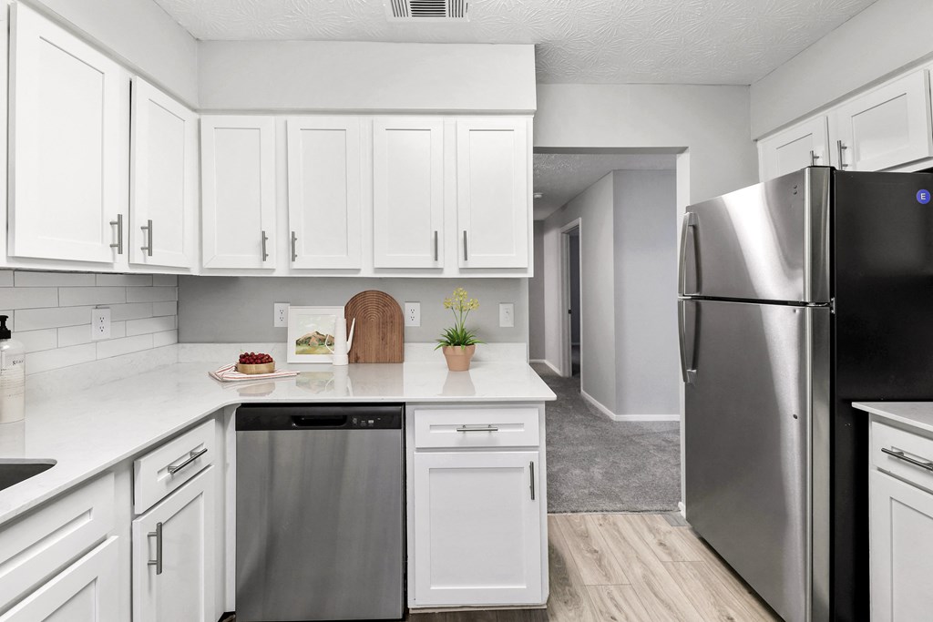 a renovated kitchen with white cabinets and stainless steel appliances