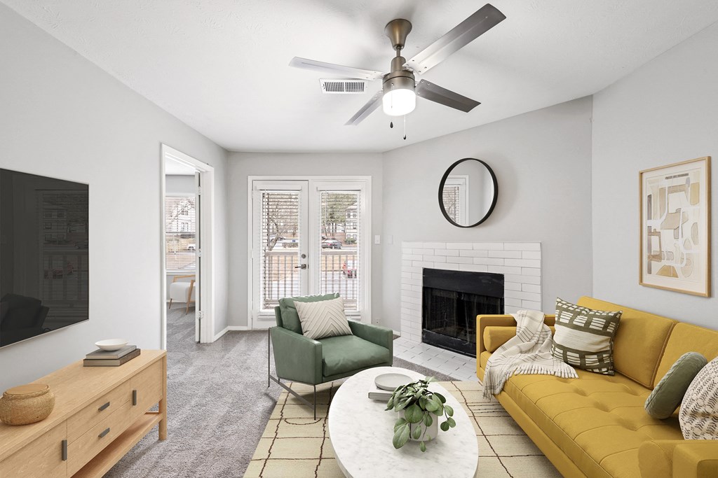 a living room with a ceiling fan and a fireplace