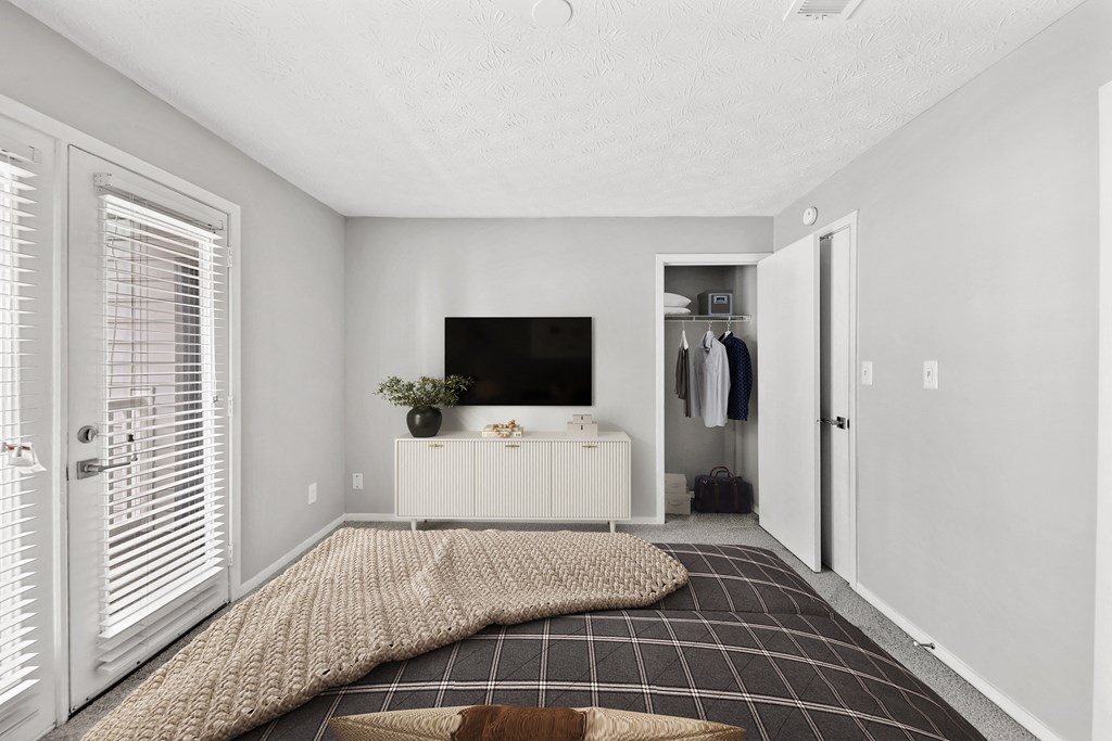 a bedroom with a bed and a dresser and a tv