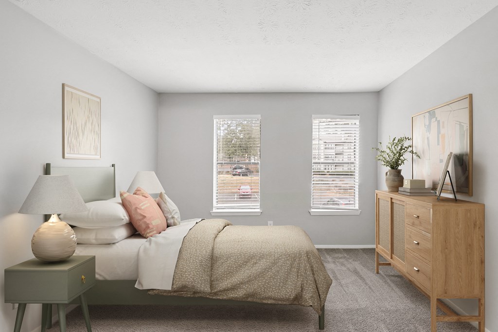 a bedroom with a bed and two windows