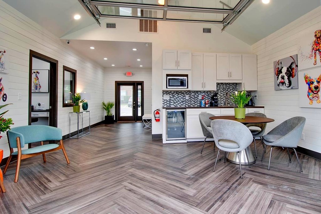 A modern kitchen with a wooden floor and a dining table with chairs.