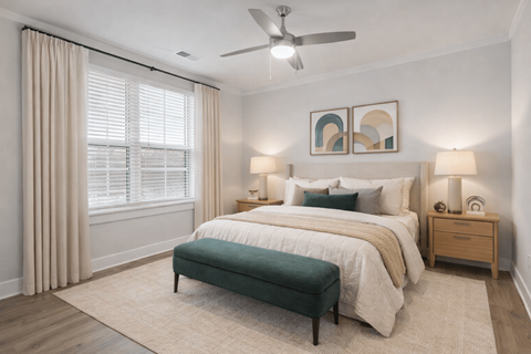 A bedroom with a large bed, a bench, and a ceiling fan.