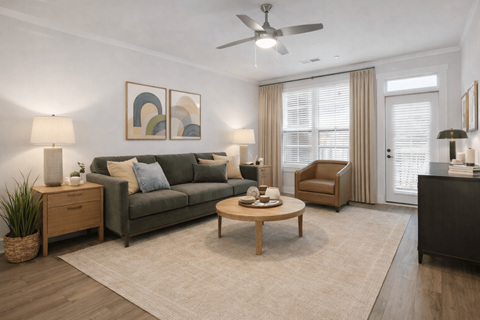 A living room with a grey couch, a wooden coffee table, and a ceiling fan.
