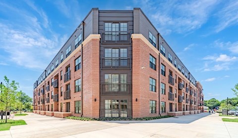 A large red brick building with a lot of windows and balconies.