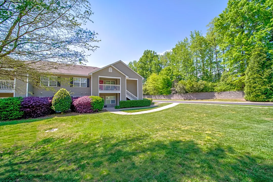 a house with a yard and a sidewalk in front of it