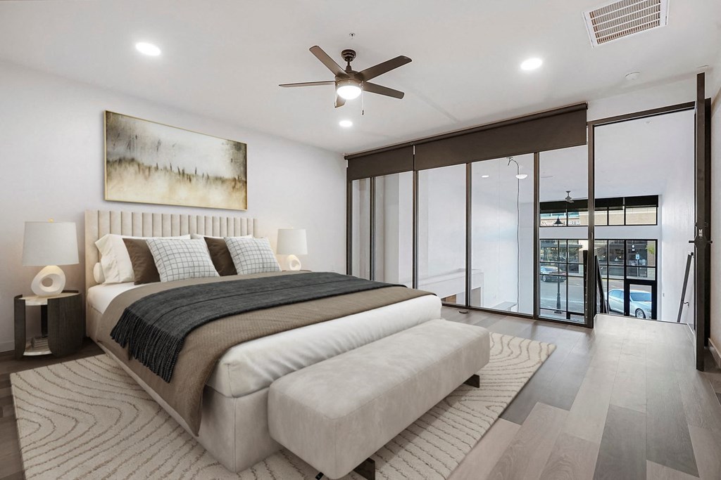 a white bedroom with a large bed and a ceiling fan