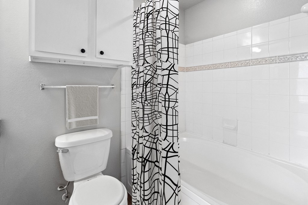 a bathroom with a shower curtain and a toilet