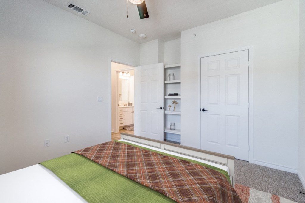 a bedroom with a bed and a closet and a door to a bathroom