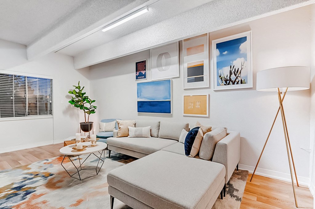 A living room with a grey couch, a small table, and a floor lamp.