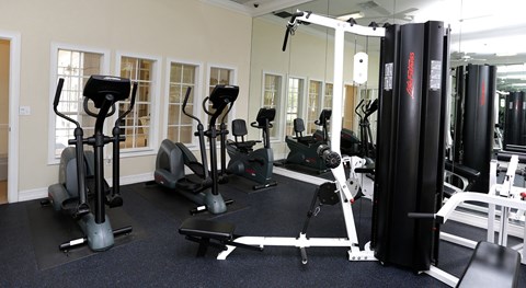 A gym with a variety of equipment including treadmills, stationary bikes, and weight machines.