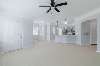 A spacious room with a ceiling fan and lighting fixtures.