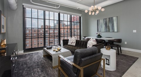 A living room with a large window and a view of a city skyline.