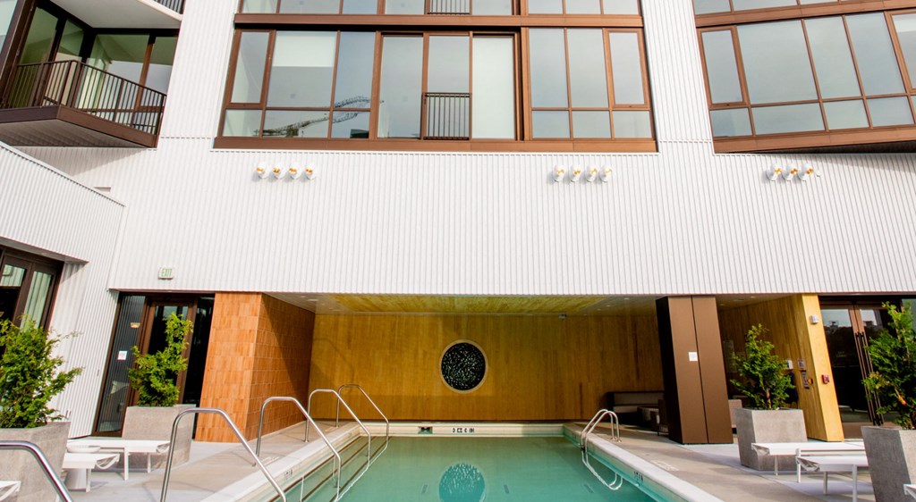 A modern building with a pool in front.