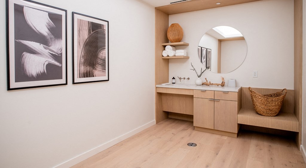 A bathroom with a vanity and two framed pictures on the wall.