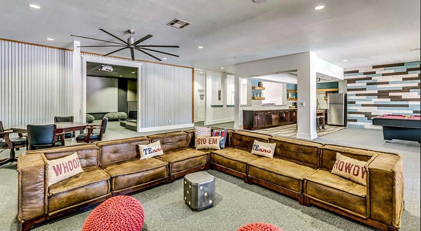 a living room with a large couch and a pool table