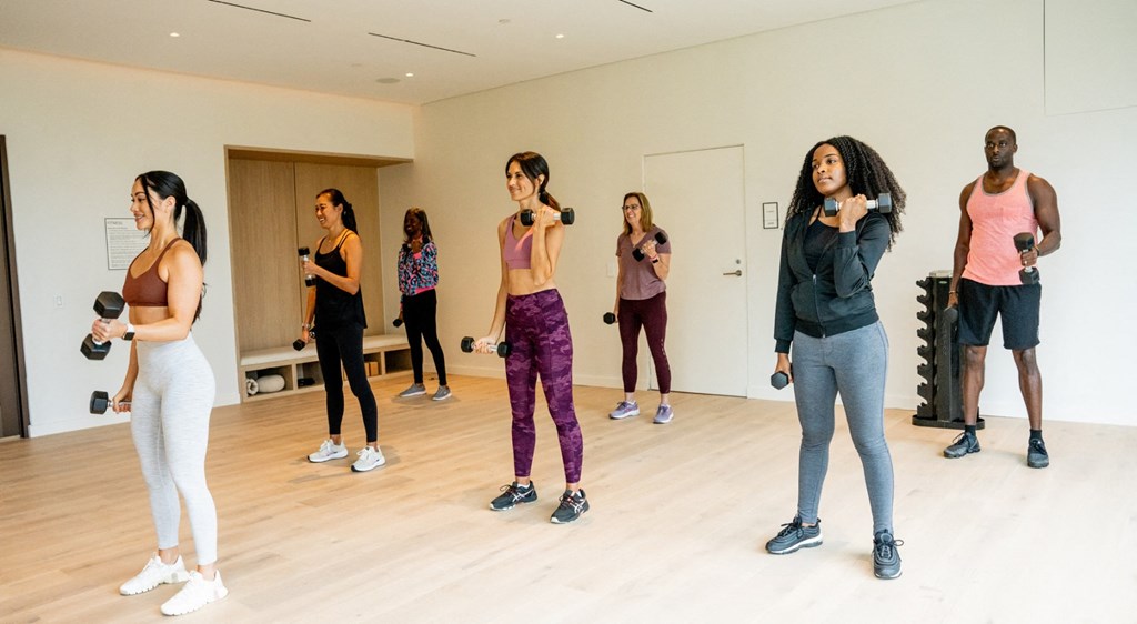 A group of people are exercising in a spacious room.