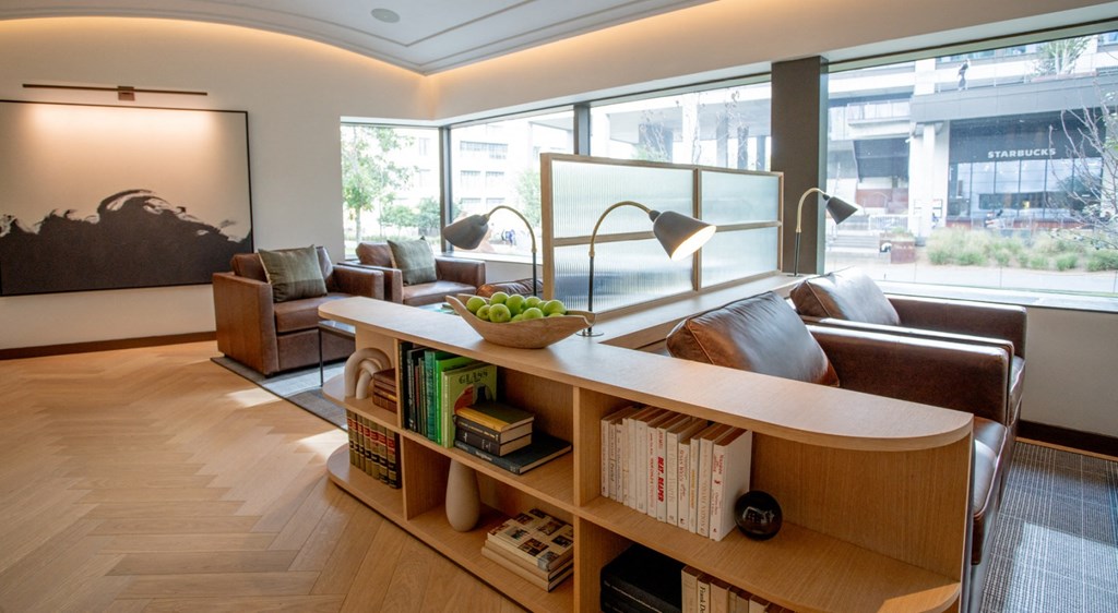 A room with a long wooden bookshelf and a large window.