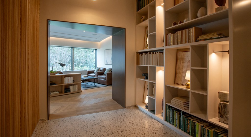 A room with a large mirror and a bookshelf filled with books.
