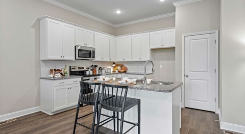 A kitchen with white cabinets and a granite countertop.