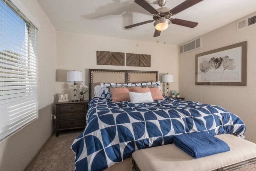 a bedroom with a bed and a ceiling fan