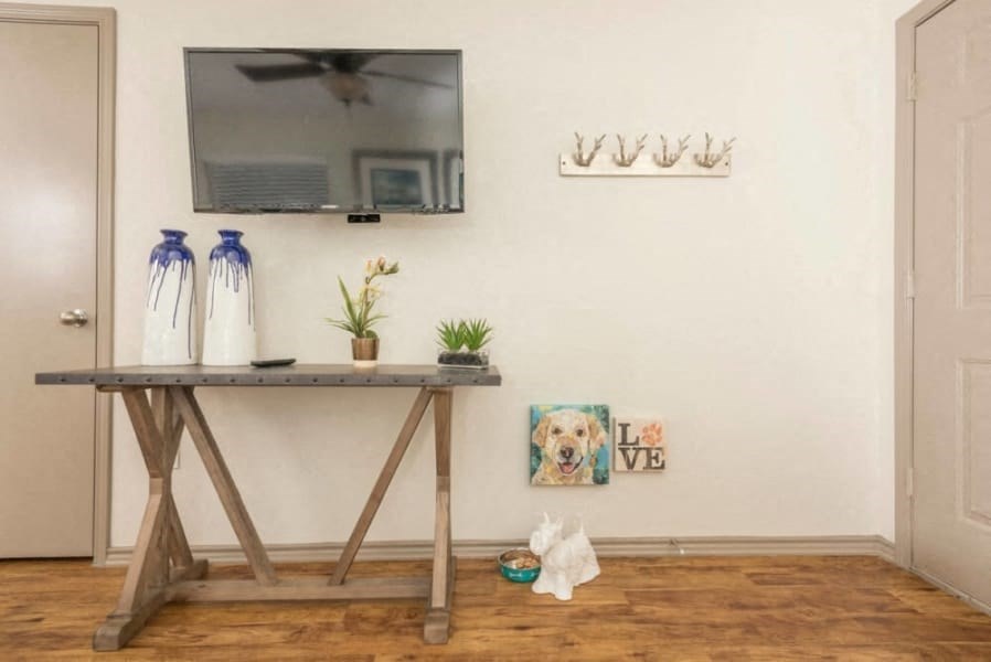 a living room with a table and a tv on the wall