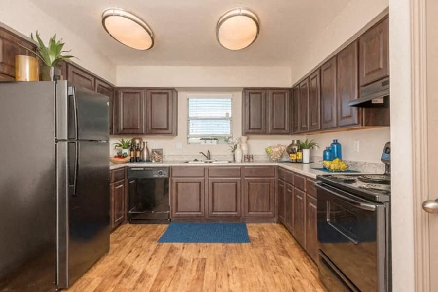 a kitchen with stainless steel appliances and wooden floors