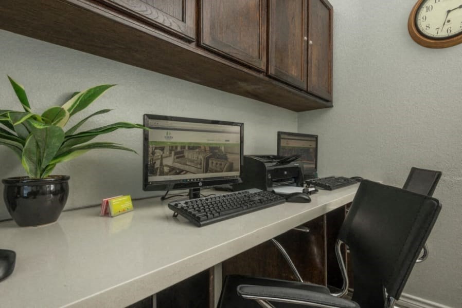 an office with a desk with a computer and a chair