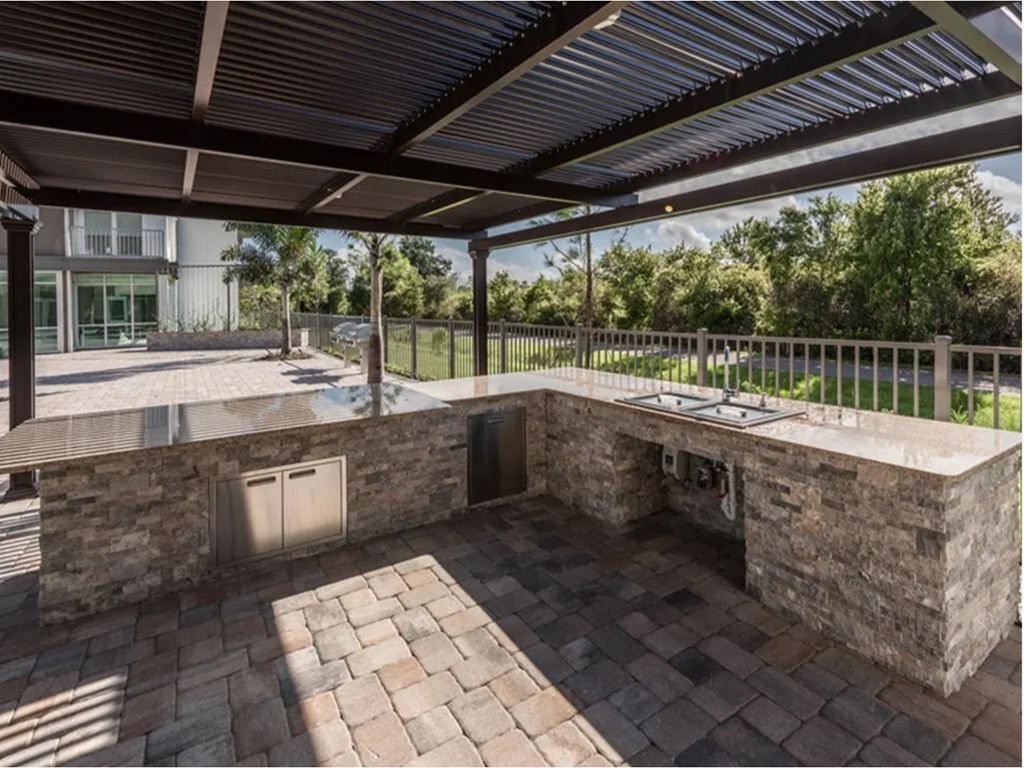 a patio with a kitchen and a pool